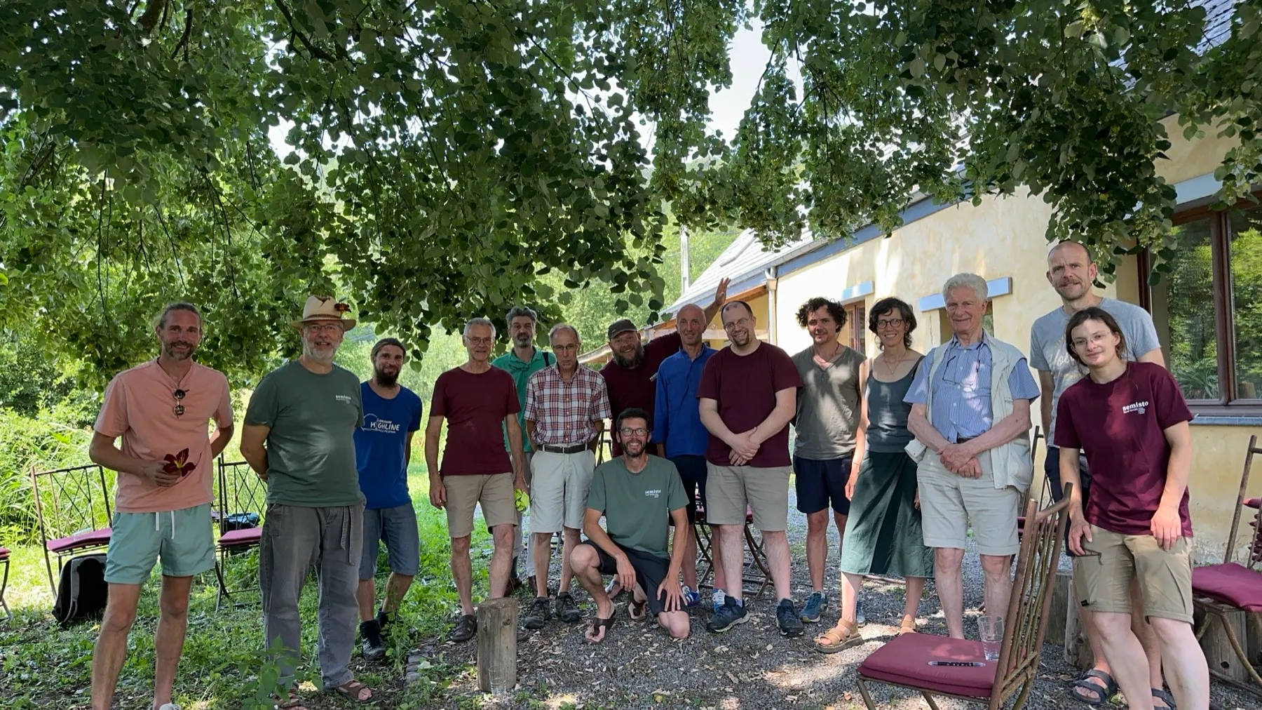 Alec and his Semisto program cohort gathered under a lime tree, in front of a yellow-walled building