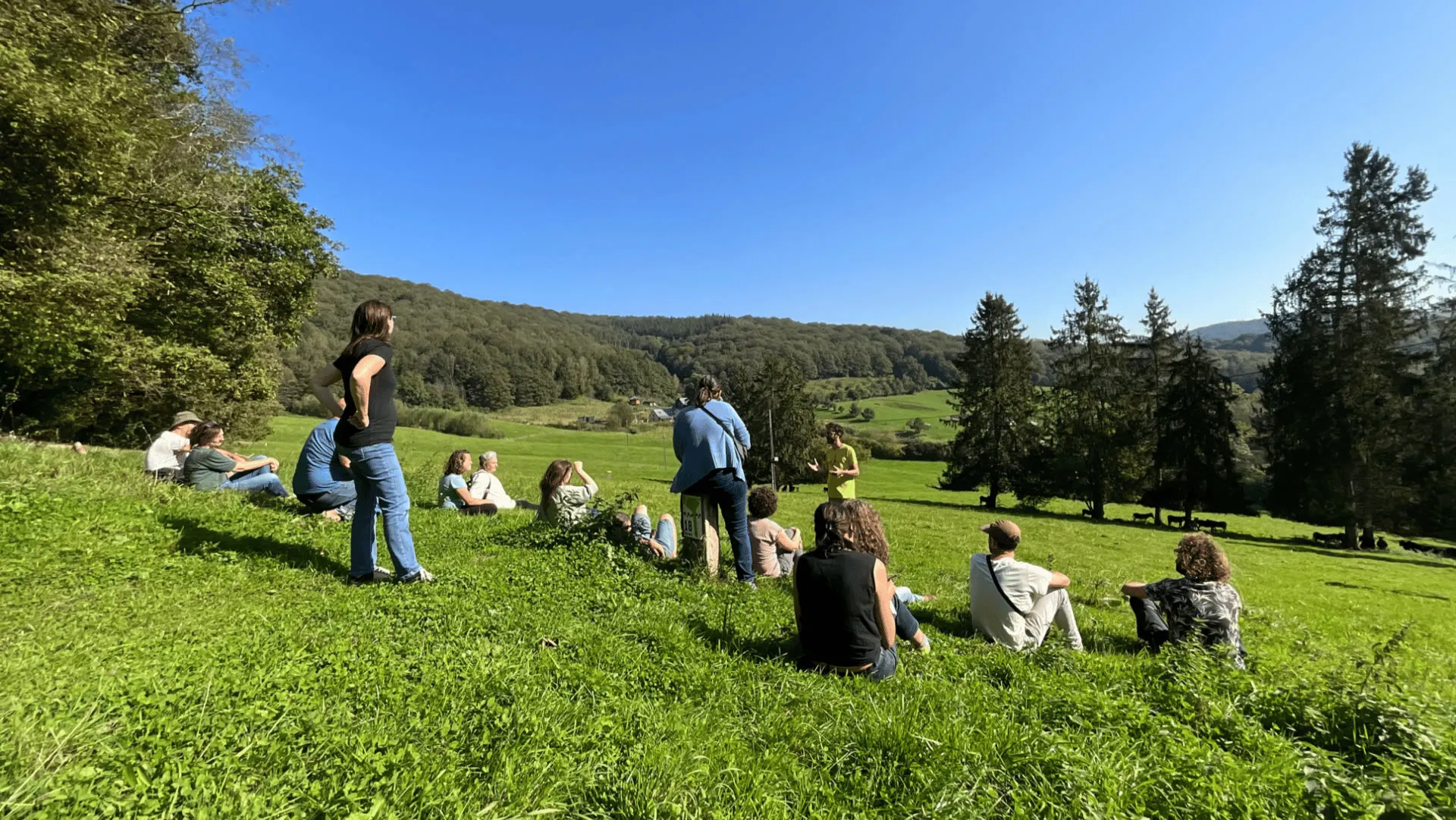 Group landscape reading in the Les 4 Sources valley in Yvoir, under a blue sky