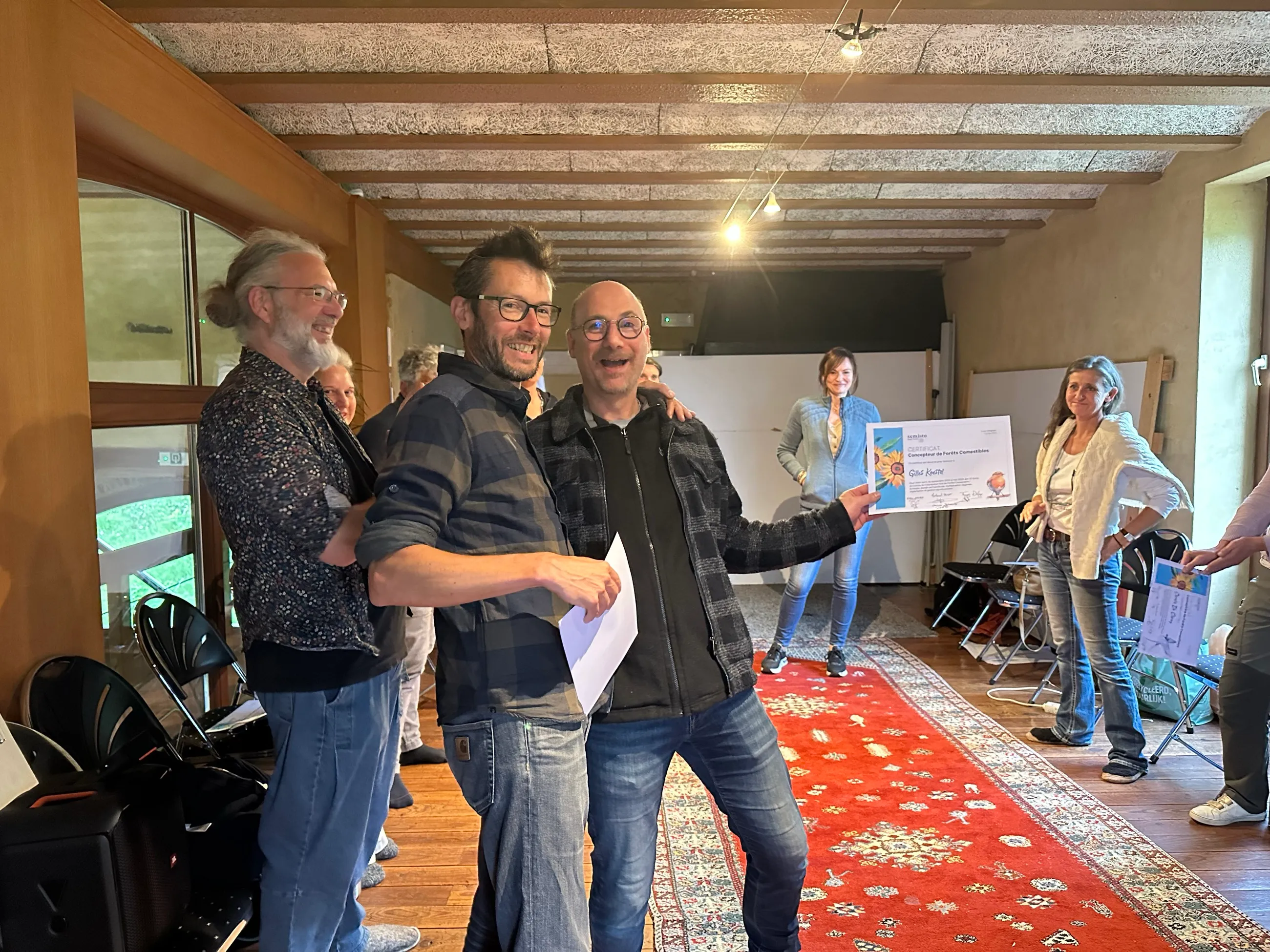Deux diplômés brandissent leur certificat de Concepteur de Forêts Comestibles, tout sourire