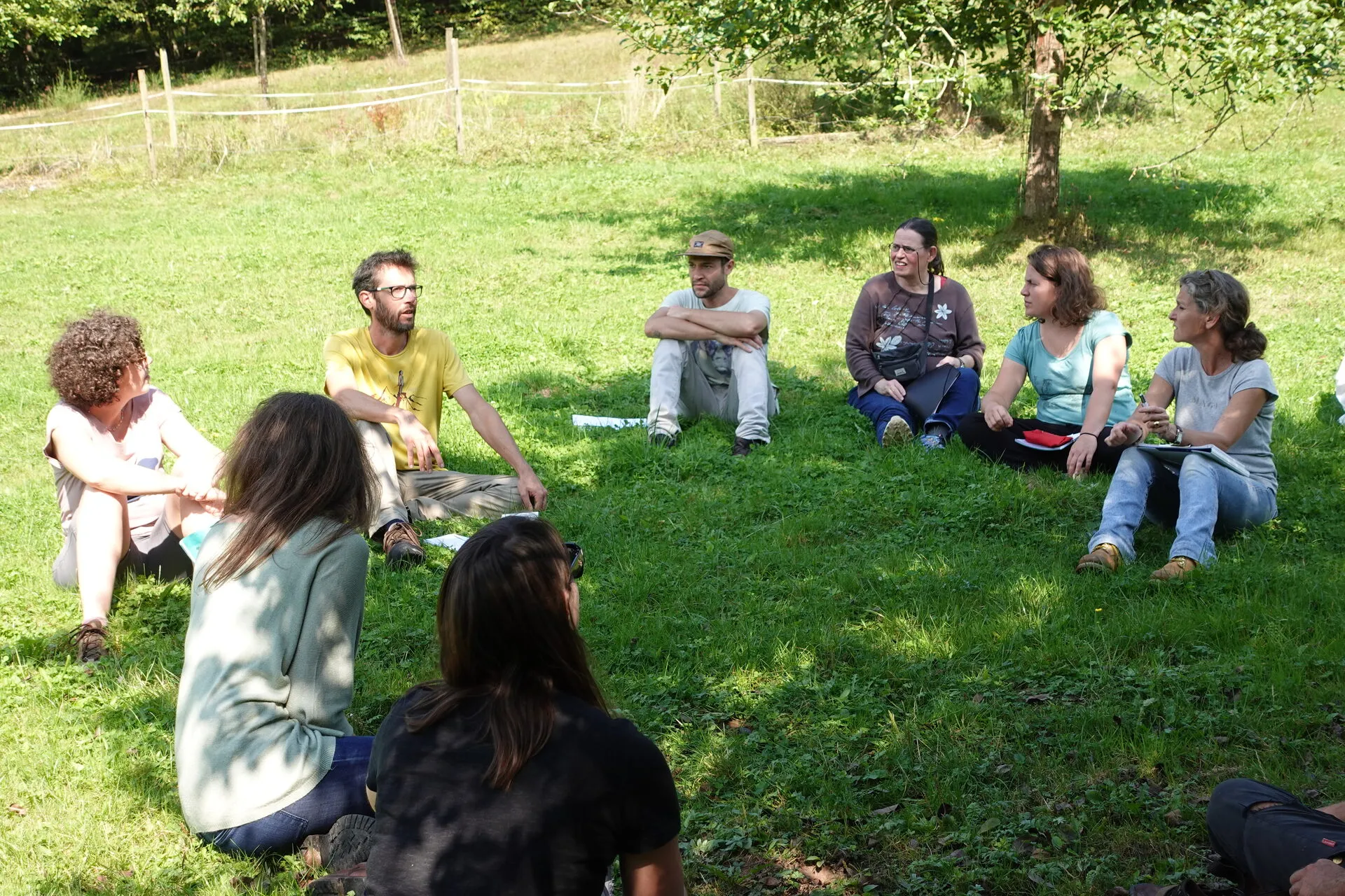 Un groupe en formation, assis en cercle dans l'herbe